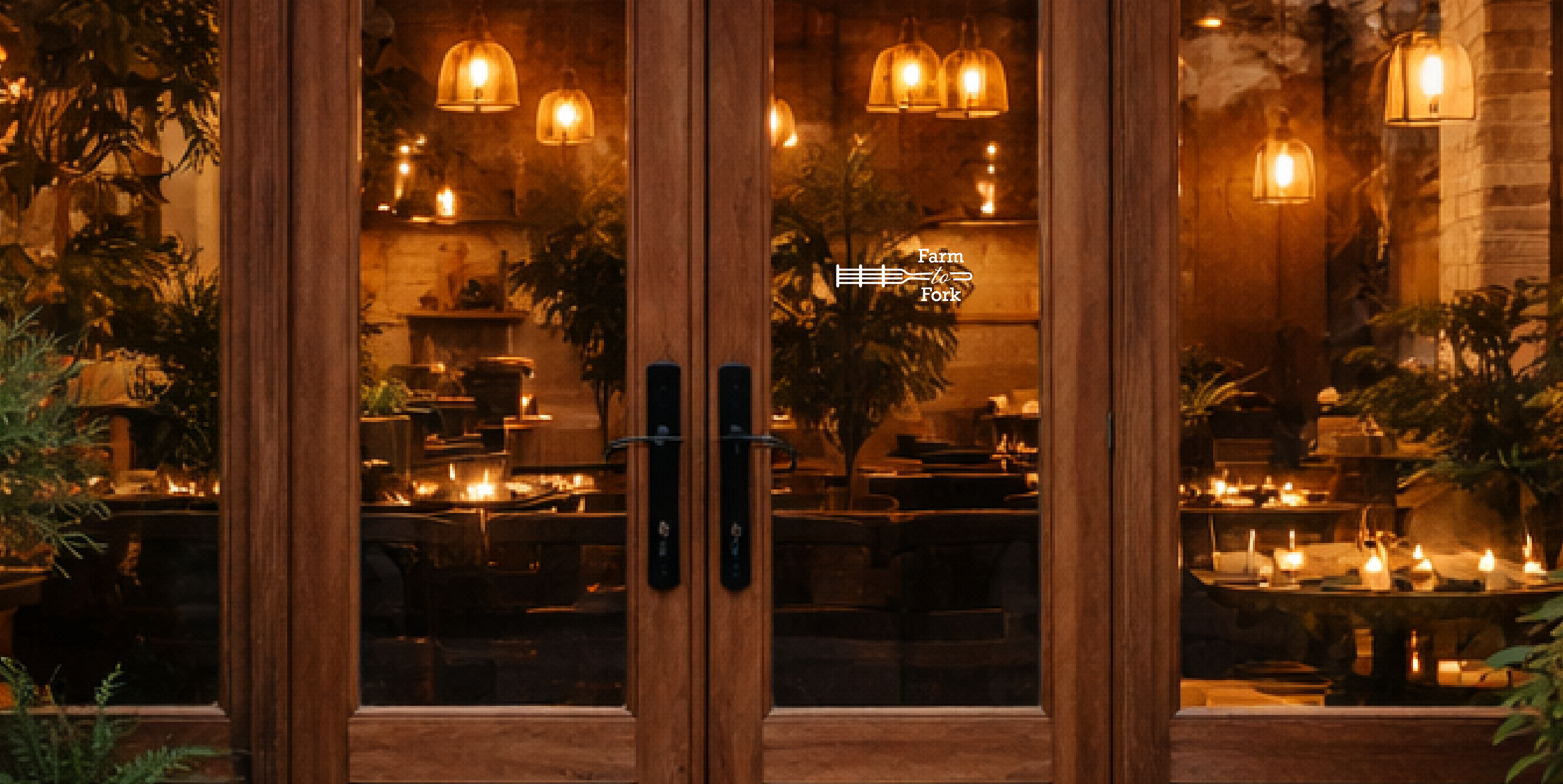 Dining area with candles and plants through a glass door with a decal on the front