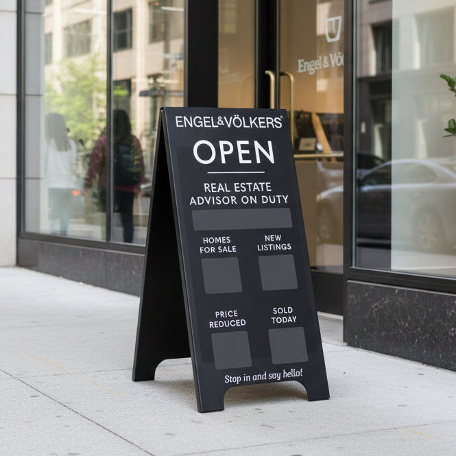 Real estate sign in front of a building with 'Engel & Völkers' branding.