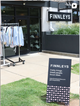 Finnleys store exterior with a sign and clothing rack outside.