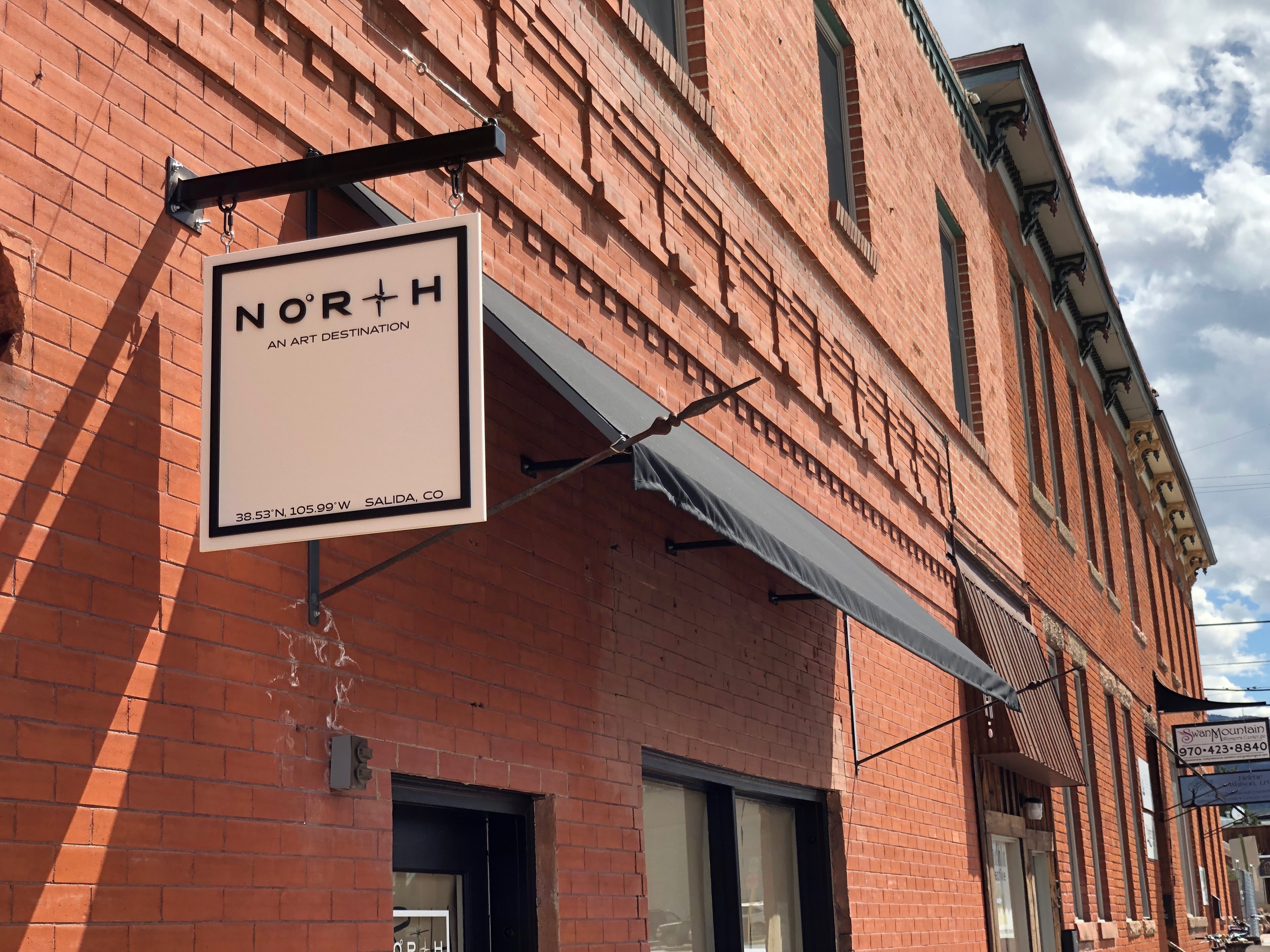 Brick building with a sign reading 'NORTH' against a cloudy sky.