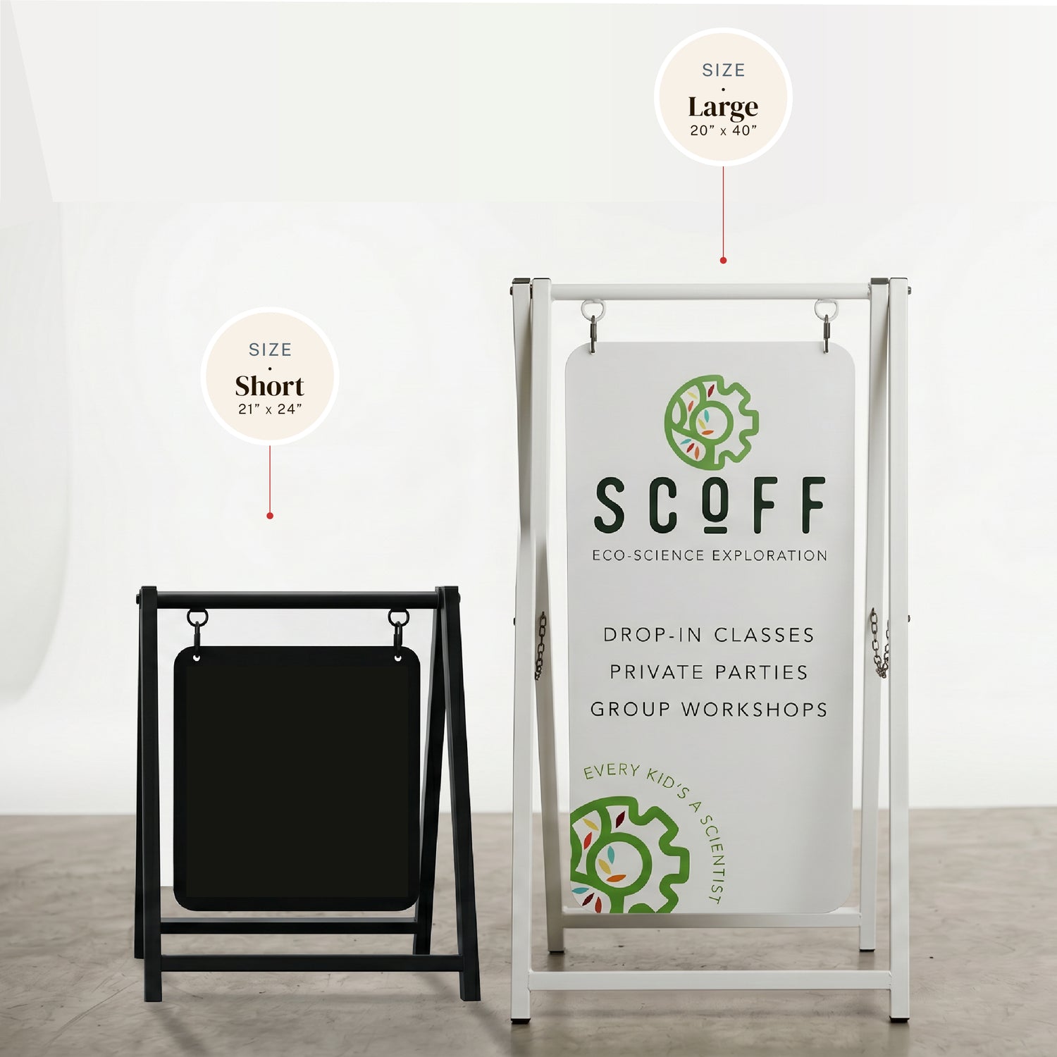 Two a-frame signs, one black and one white with green and black text, on a plain background with sizes listed