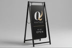 A-frame sign for a boutique with a logo and text on a white background