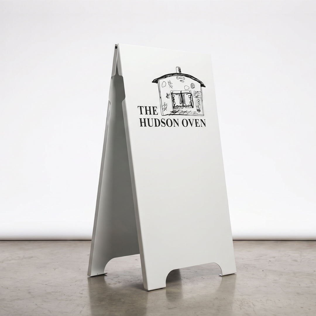 White a-frame sign with 'The Hudson Oven' branding on a white background